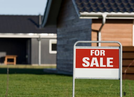 House with For Sale sign on front